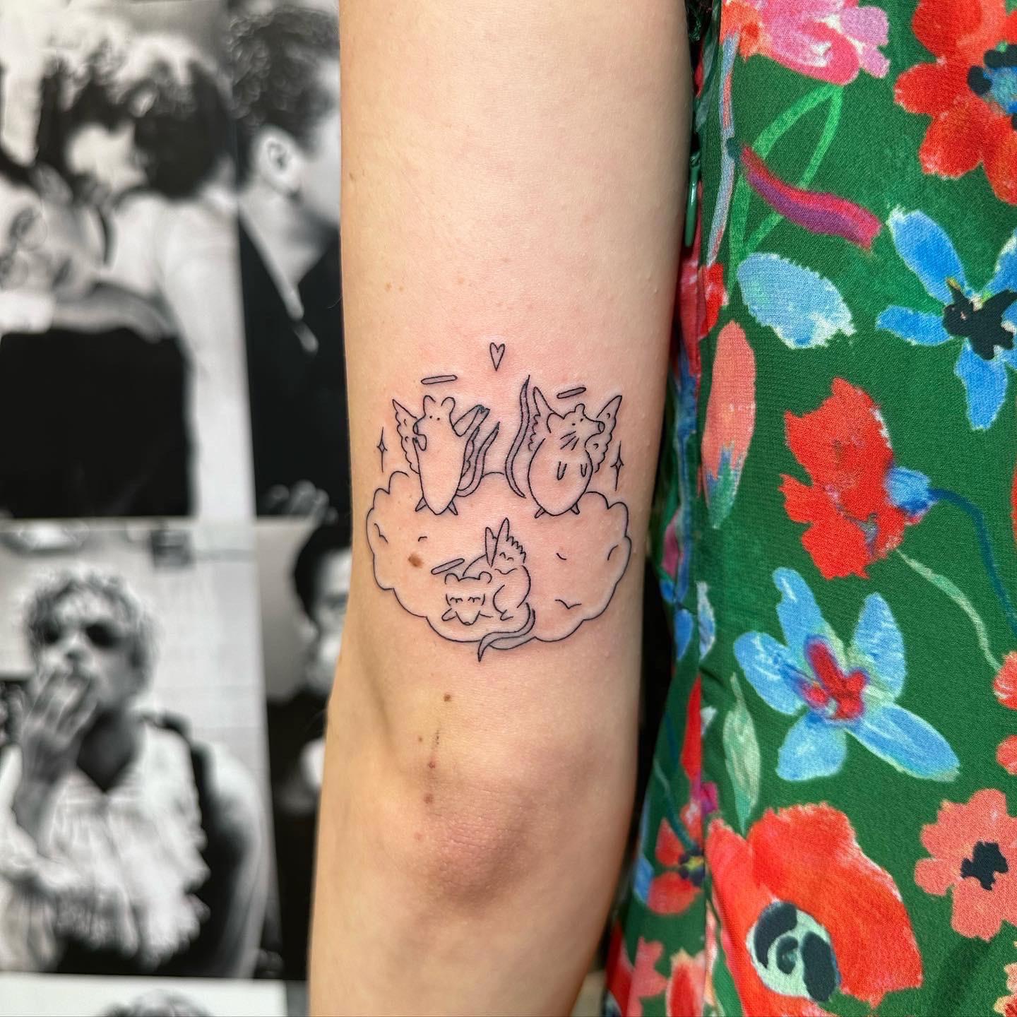 Memorial rat tattoos on a person's inner arm and a mirror selfie in a green floral dress