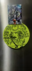 Frank Zappa fan art featuring a circular drawing of Zappa and a muscular comic character on a metallic surface