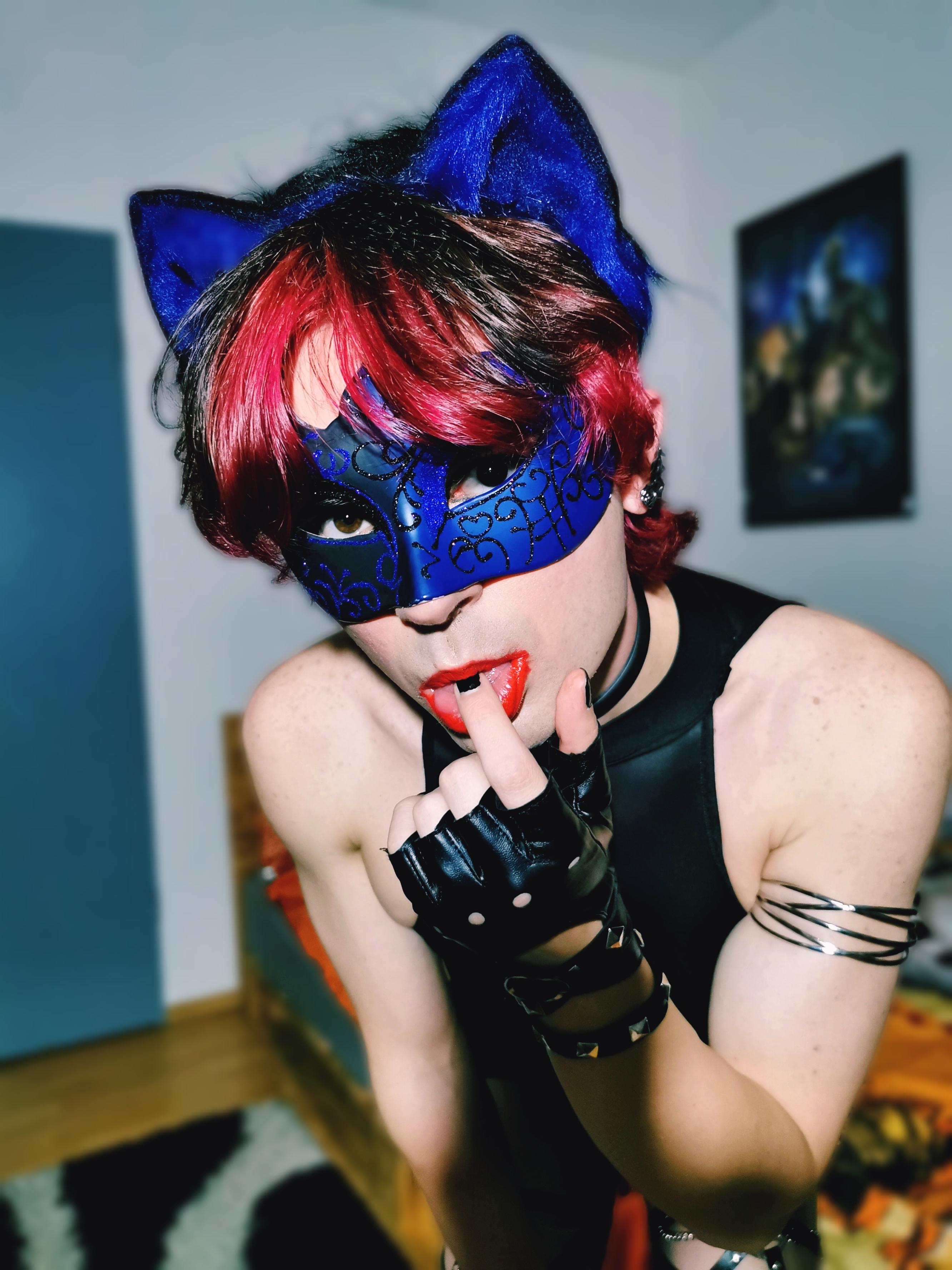 Femboy in a blue catgirl cosplay with a black bodysuit, mask, and cat ears posing for a selfie.