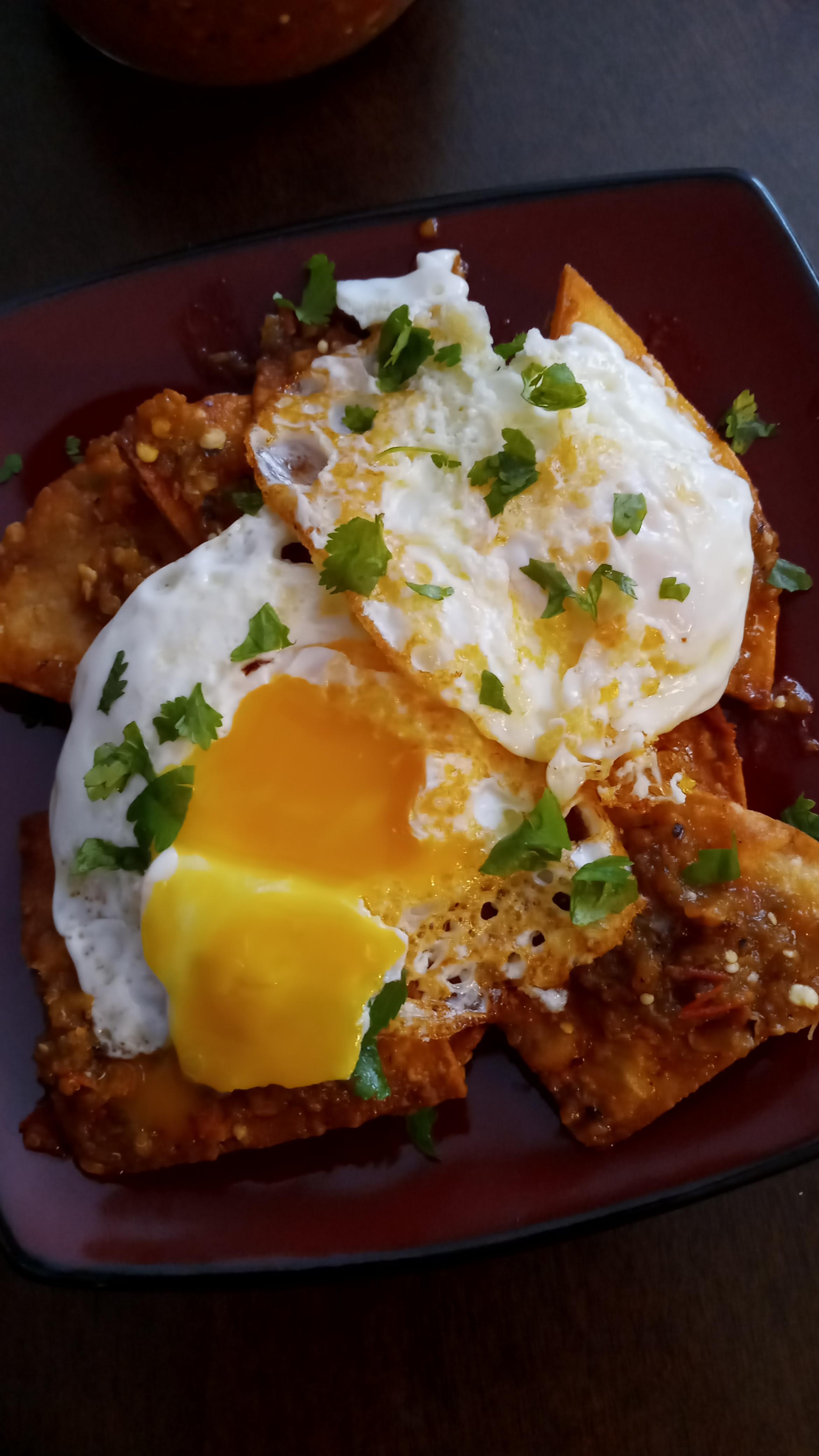 Cast iron chilaquiles breakfast with fried eggs and salsa