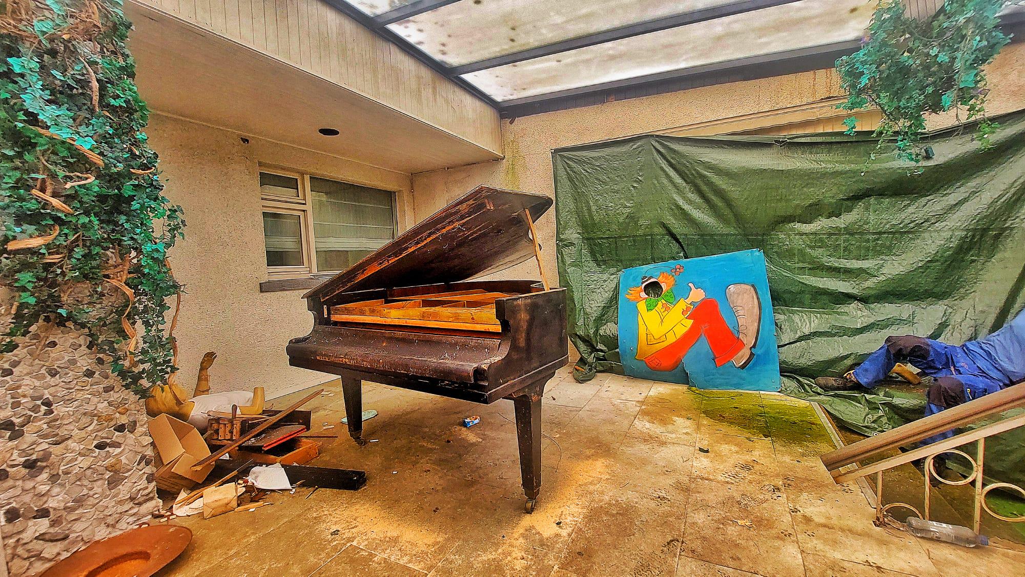 Piano, mannequin and creepy clown painting