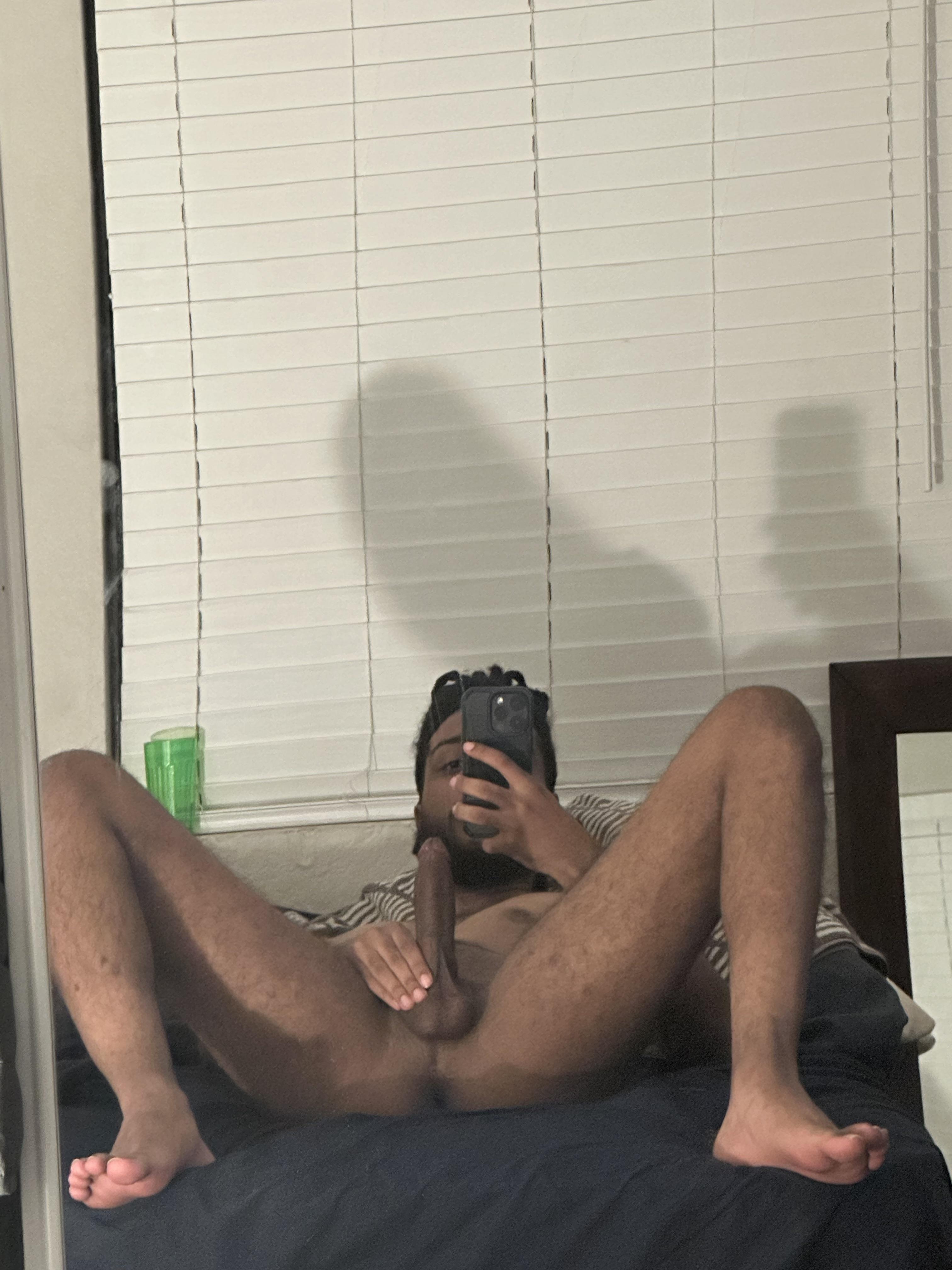 Athletic black man taking a pelfie (penis selfie) on a bed