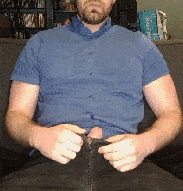 Hung dad with a brown beard in a blue button-down shirt posing with a big cock selfie