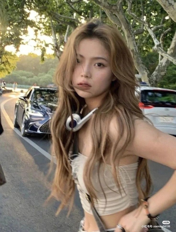 Maizee Elliott with brown, red, and blonde hair styles wearing a black lace top, beige tube top, and white top.