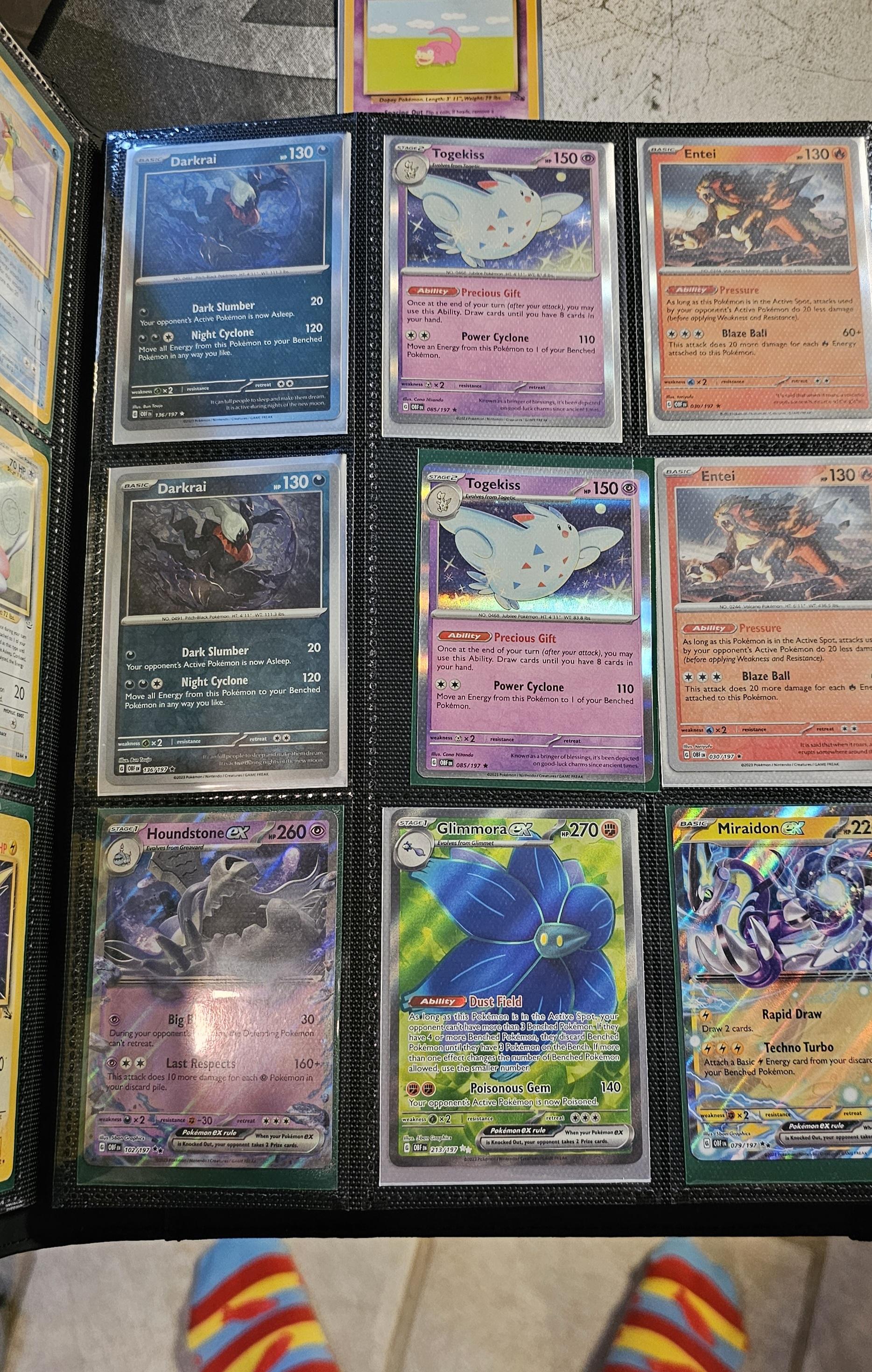 Pokémon trading cards and Misty Pokémon fan art organized in a card binder on the floor.