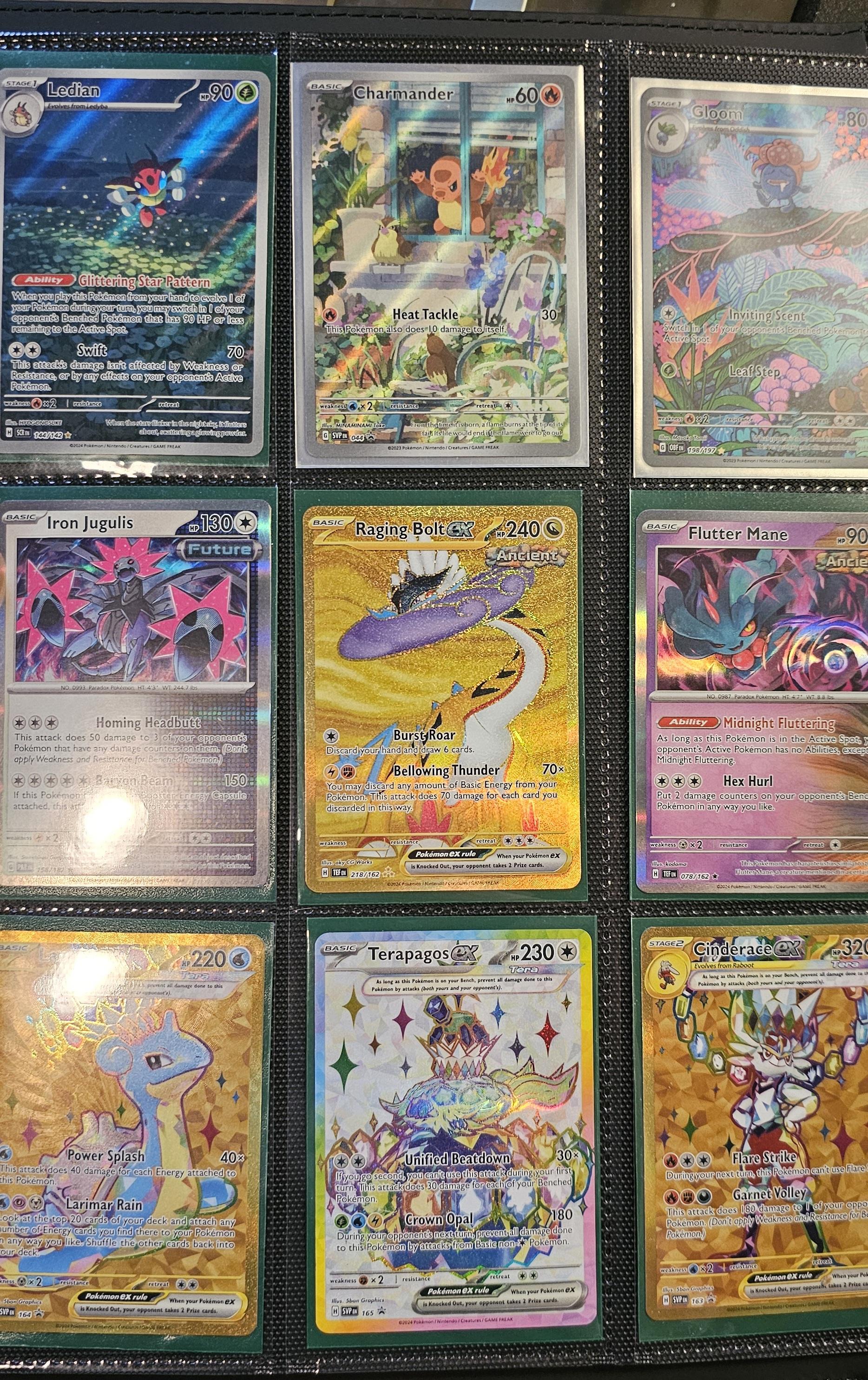 Pokémon trading cards and Misty Pokémon fan art organized in a card binder on the floor.