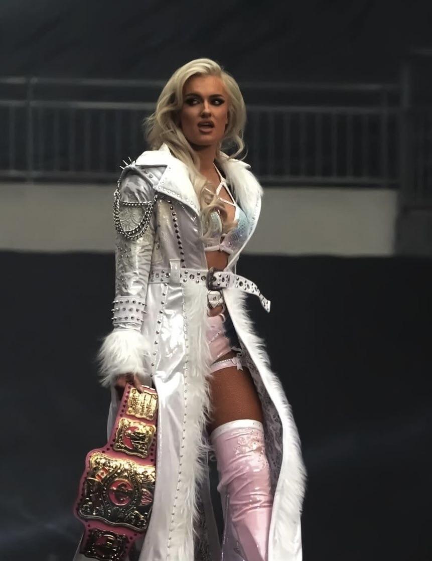 Mariah May and Toni Storm in white and silver athletic wear and sports bras posing in a wrestling ring