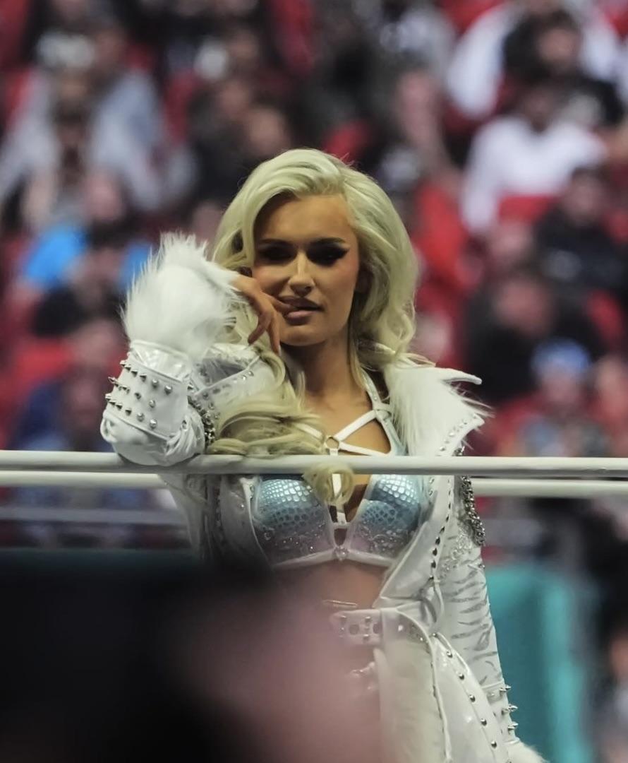 Mariah May and Toni Storm in white and silver athletic wear and sports bras posing in a wrestling ring