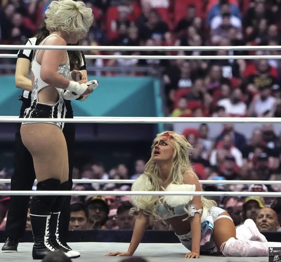 Mariah May and Toni Storm in white and silver athletic wear and sports bras posing in a wrestling ring
