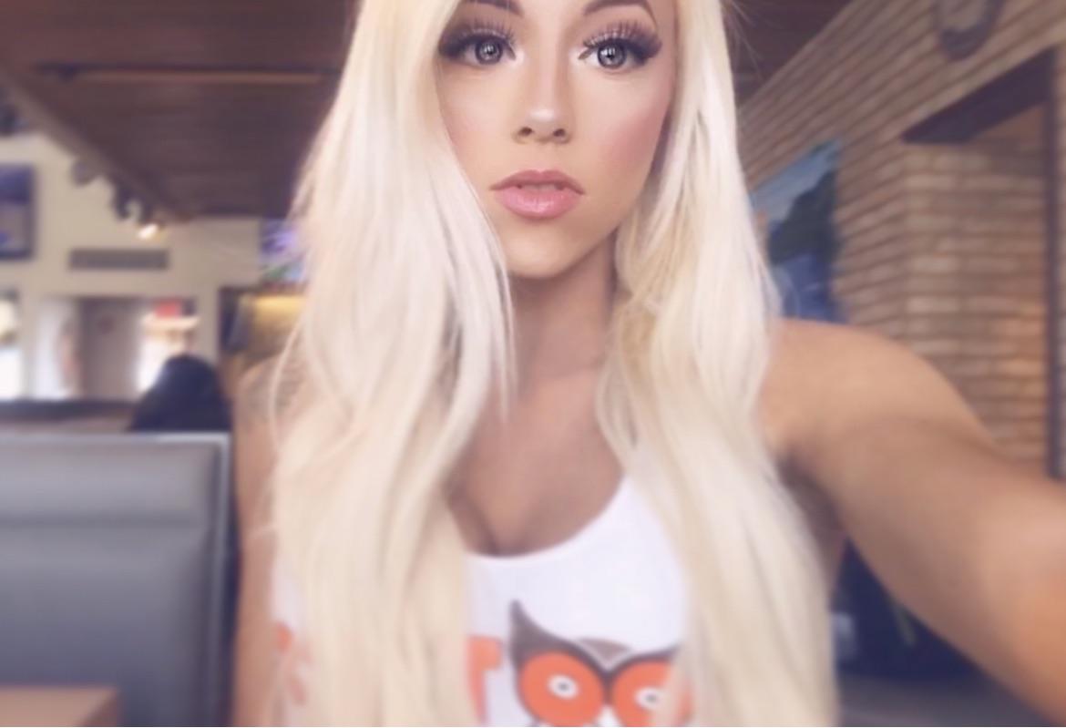 Bethany, a beautiful woman with long blonde hair and pale skin wearing a white v-neck graphic t-shirt