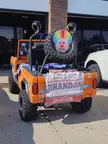 Infowarrior ride in Tulsa OK: orange off-road vehicle with a caricature on the spare tire and political banners