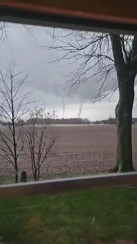 Two tornadoes joining together to form a bigger one