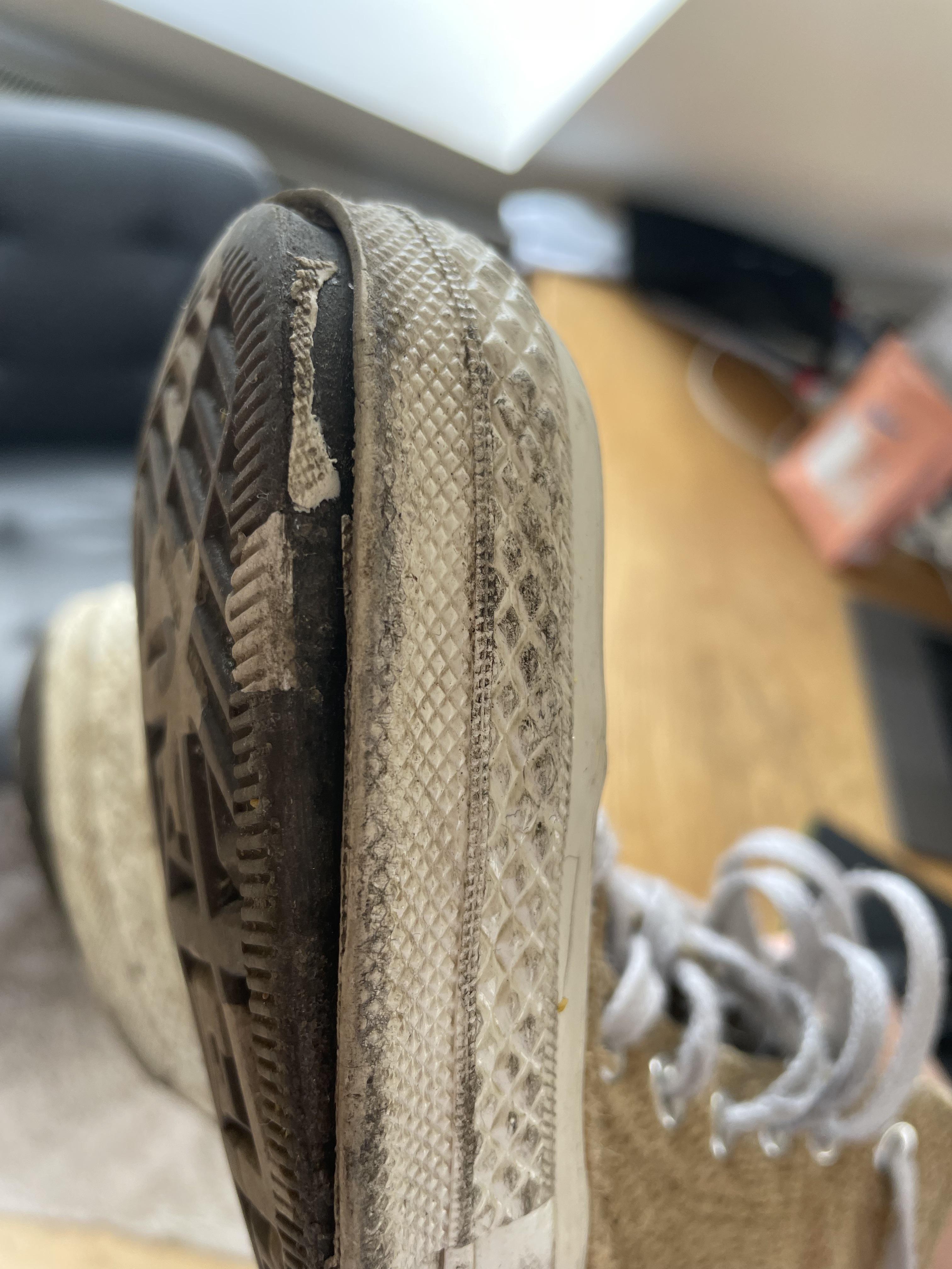 Close-up of a worn-out, dirty tan sneaker sole and side