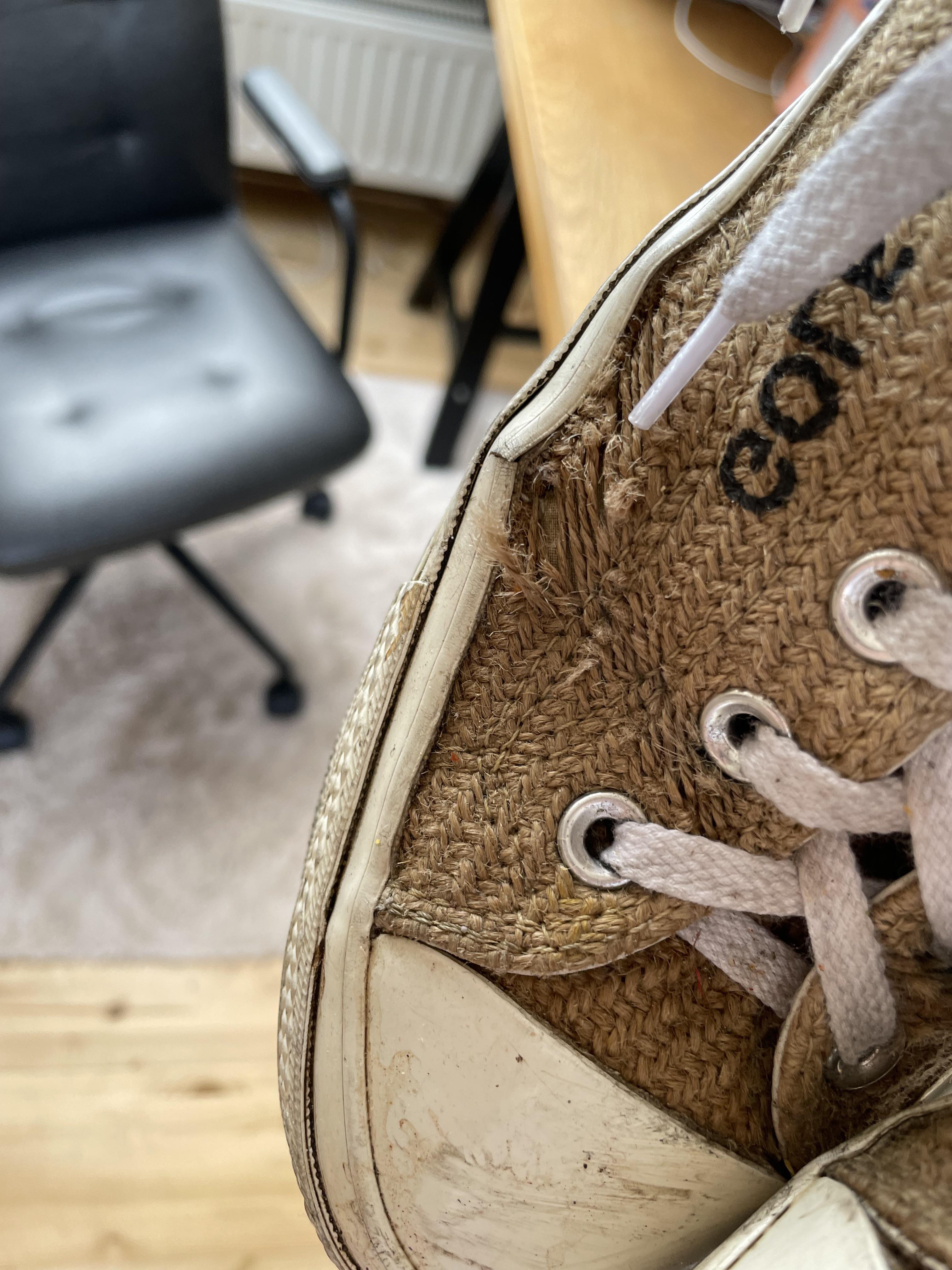 Close-up of a worn-out, dirty tan sneaker sole and side