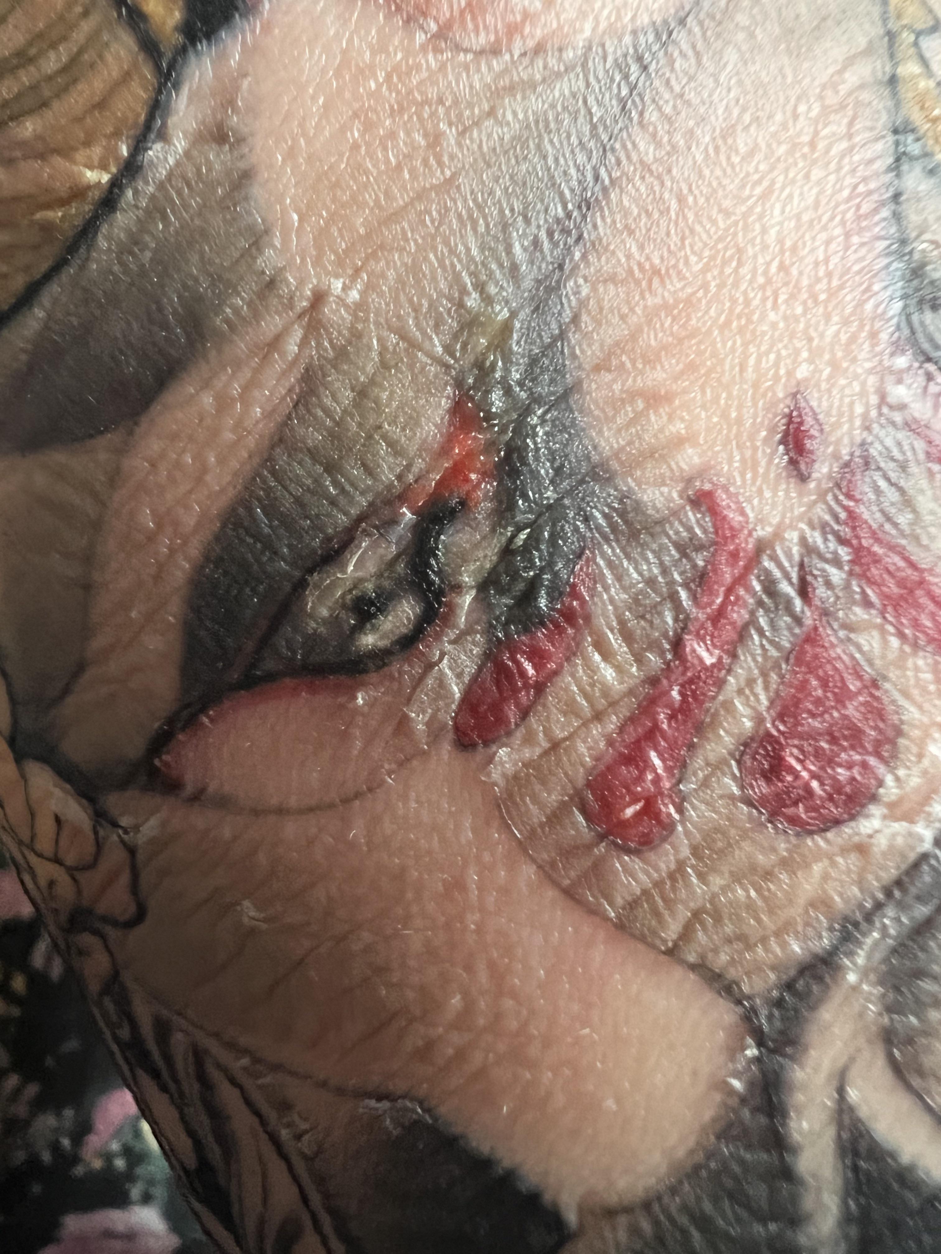 Close-up of a colorful tattoo on fair skin with redness and irritation