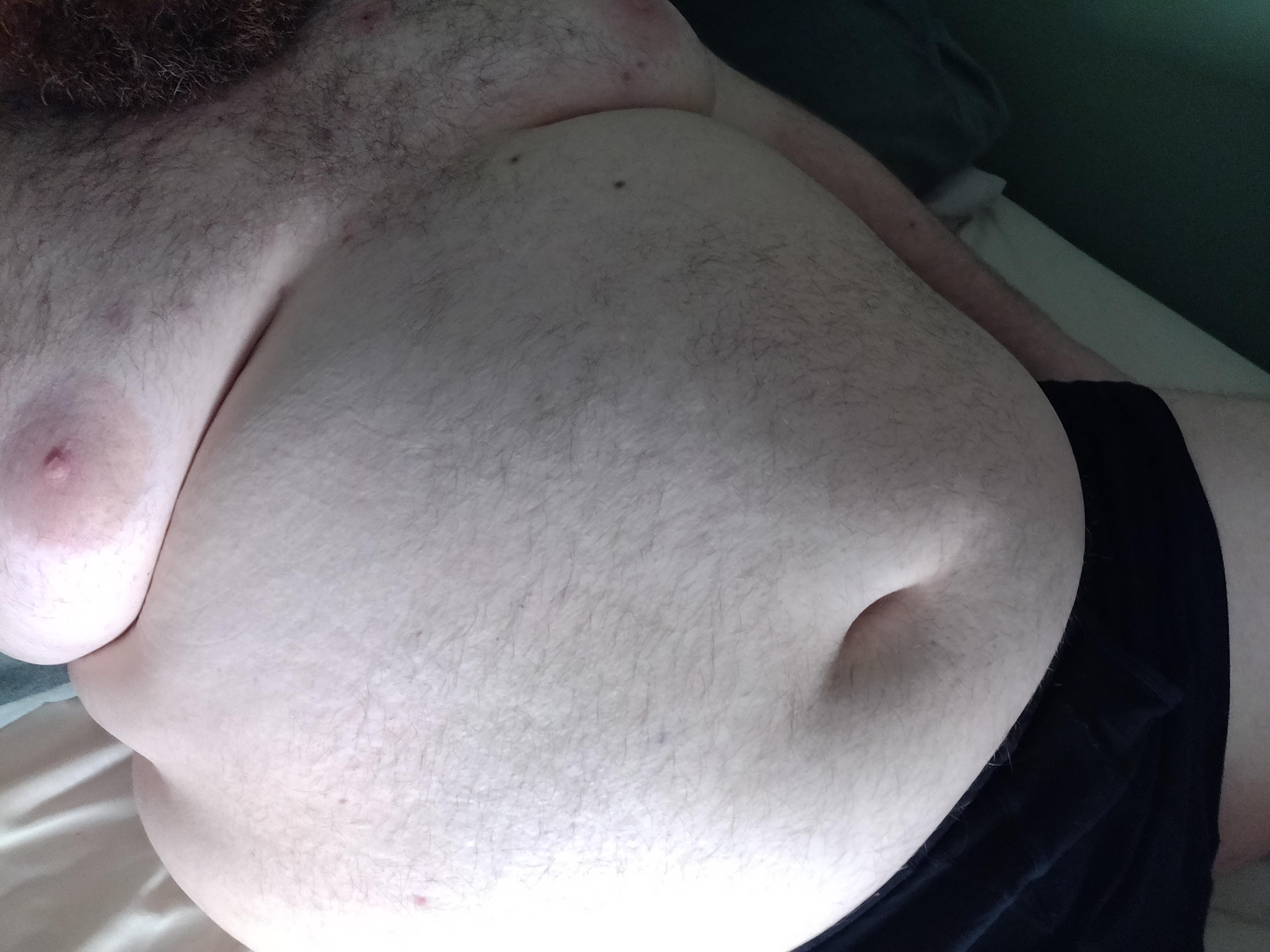 Obese white man with a hairy chest and fat belly wearing black underwear in a pelfie