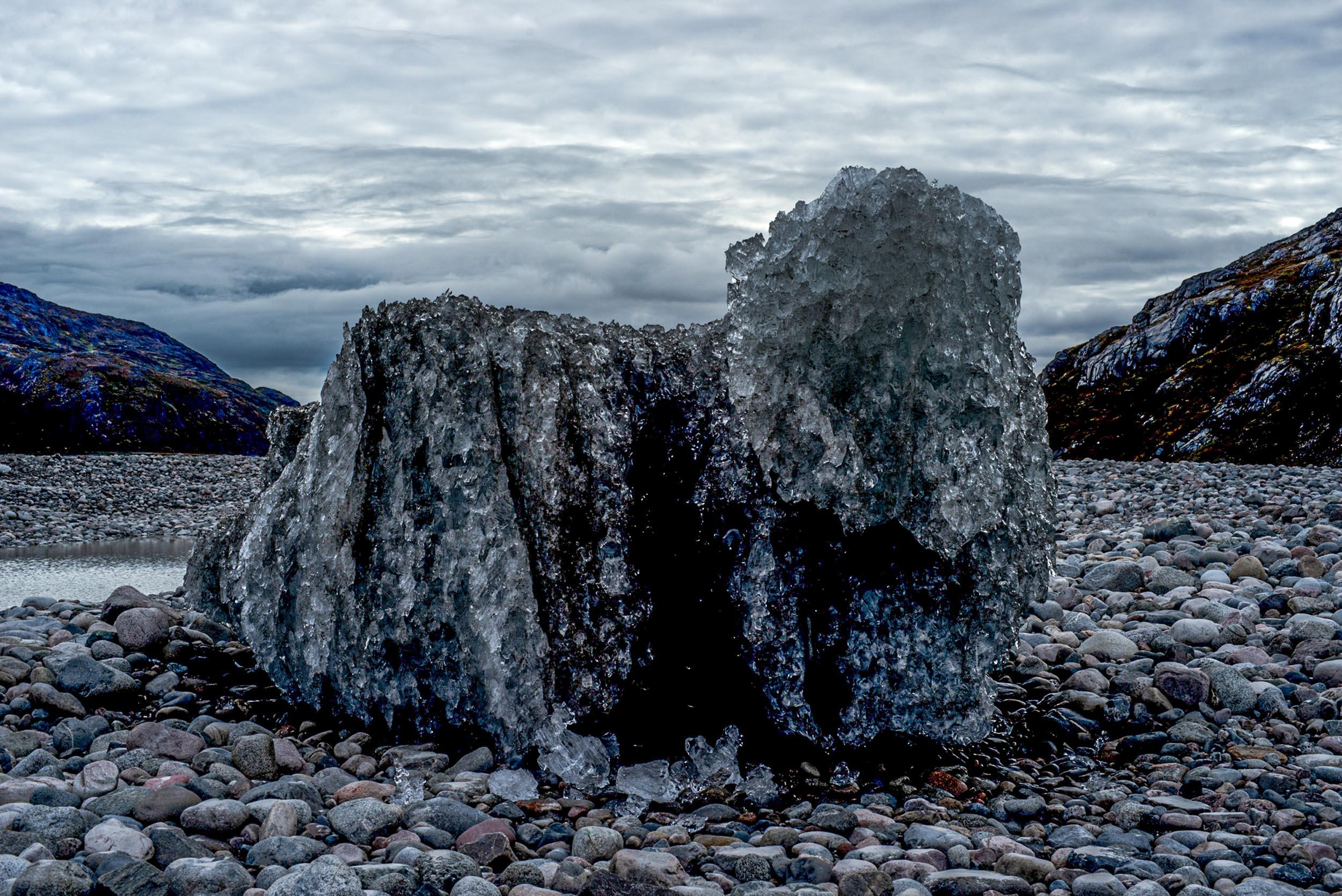 Greenland landscapes with mountains, glaciers, icebergs, a small cabin, and icy waters