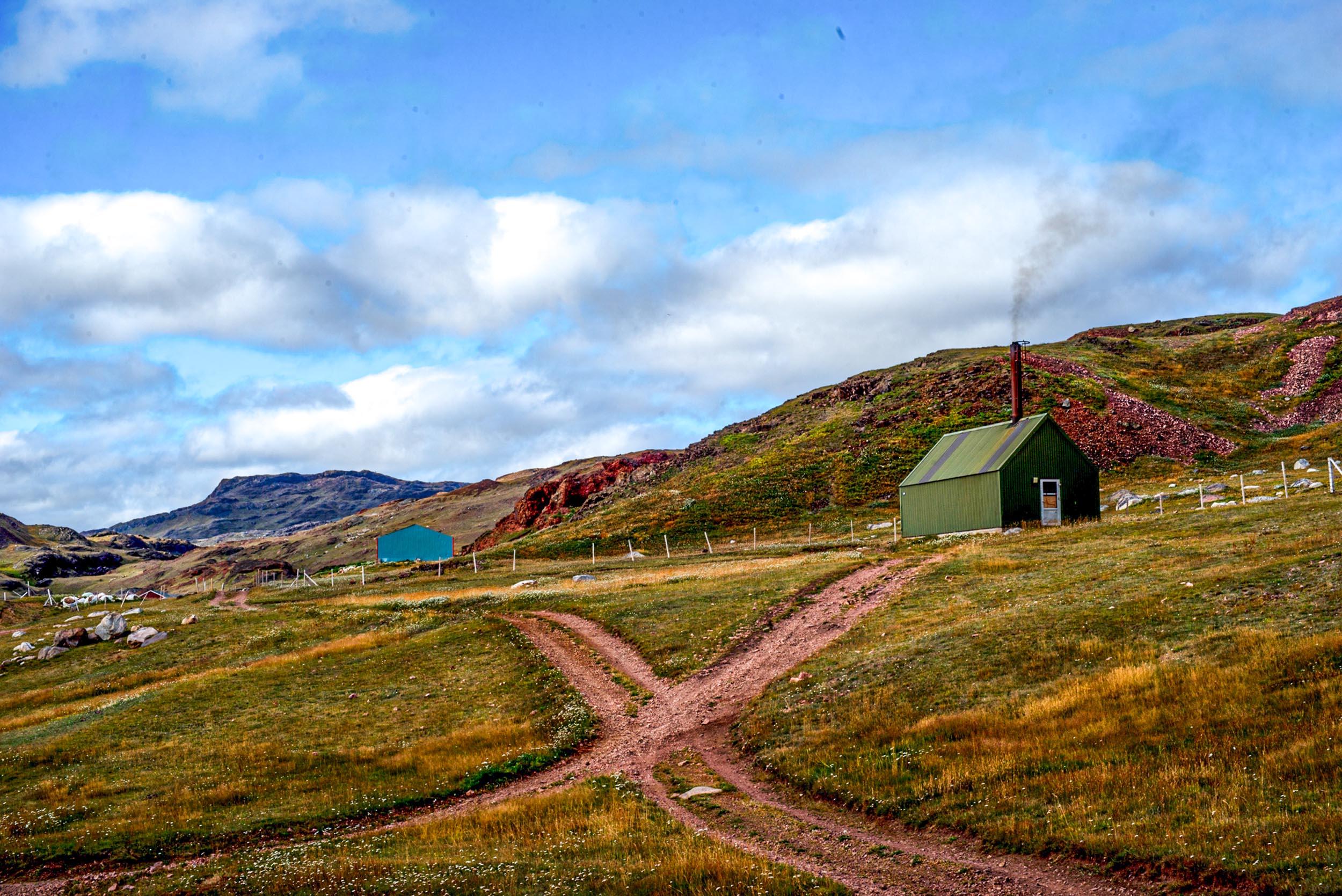 Greenland landscapes with mountains, glaciers, icebergs, a small cabin, and icy waters