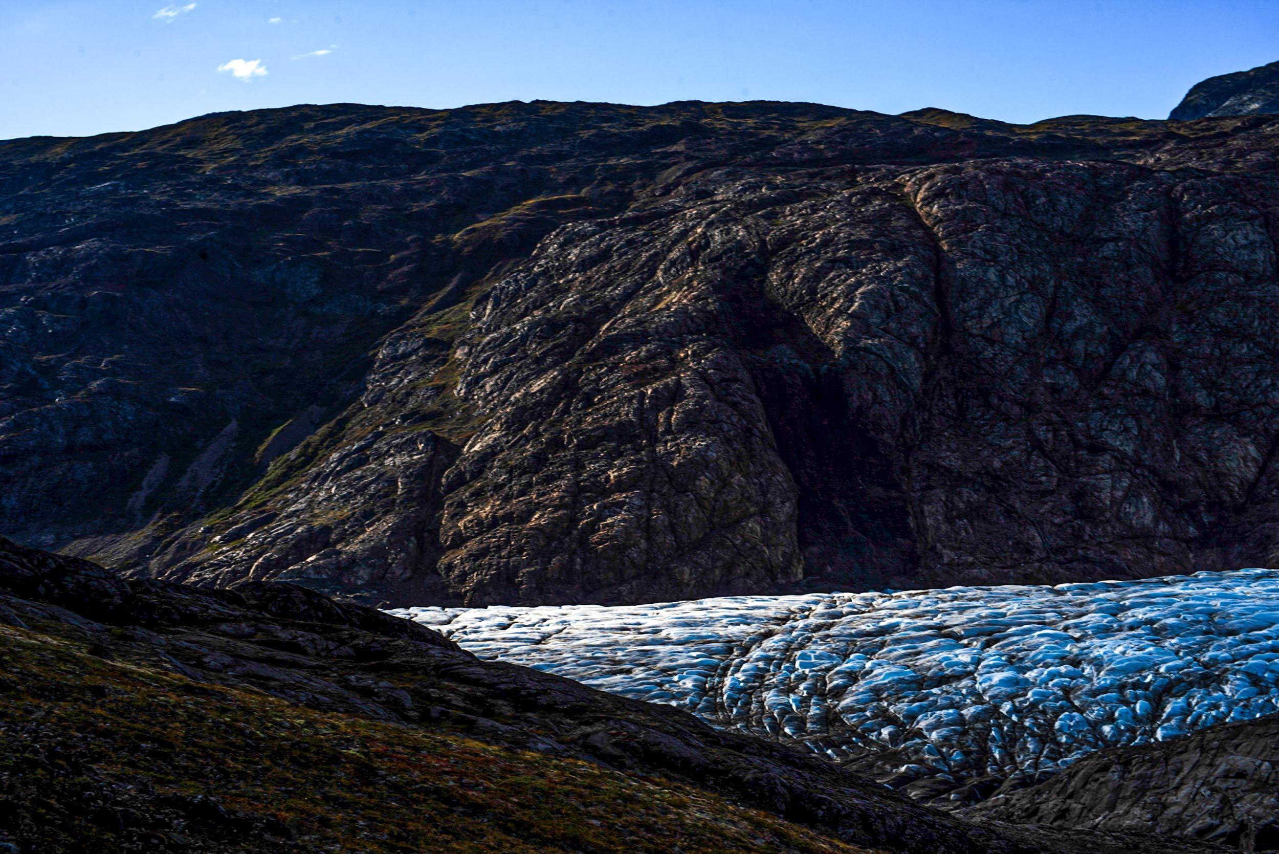 Greenland landscapes with mountains, glaciers, icebergs, a small cabin, and icy waters