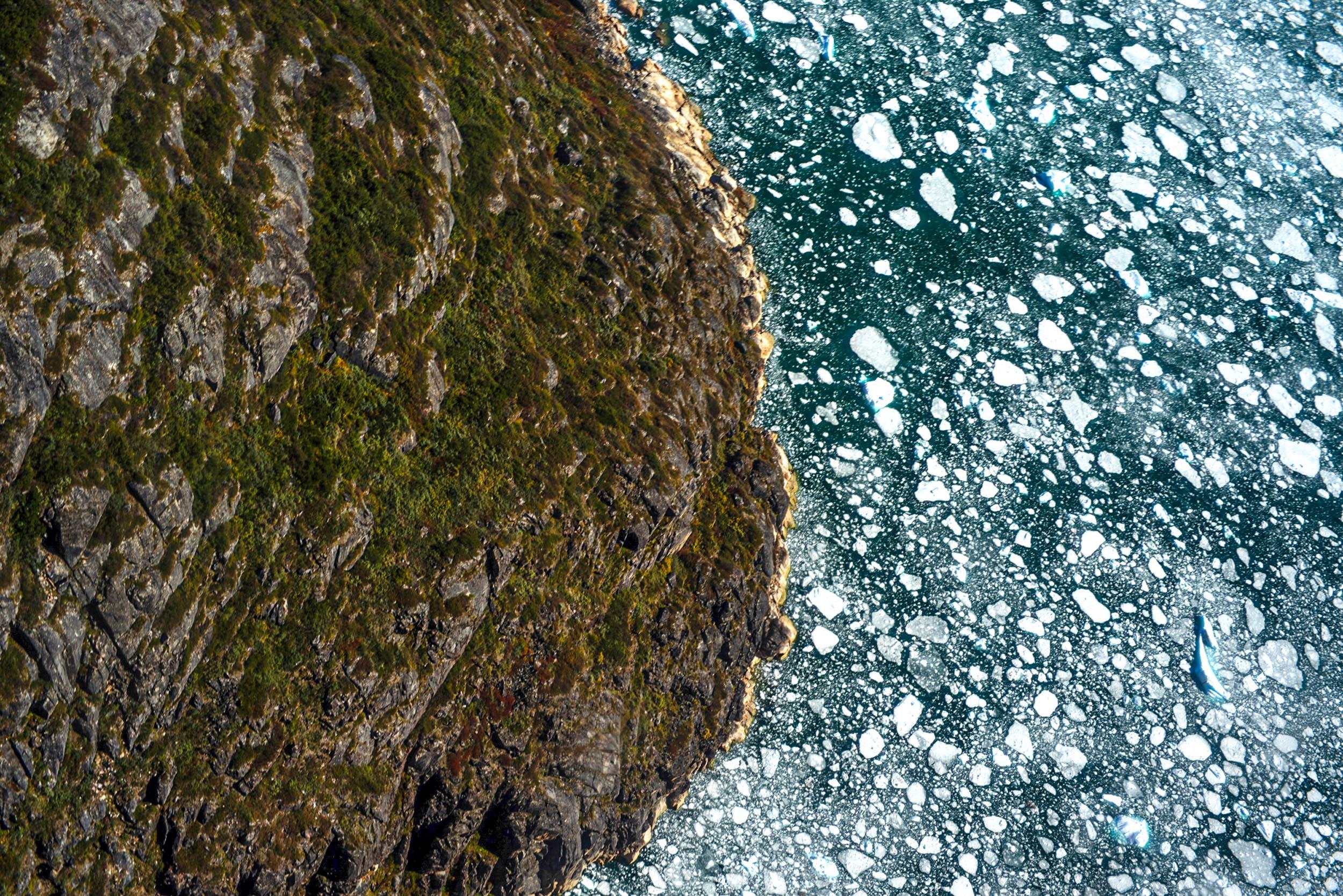 Greenland landscapes with mountains, glaciers, icebergs, a small cabin, and icy waters