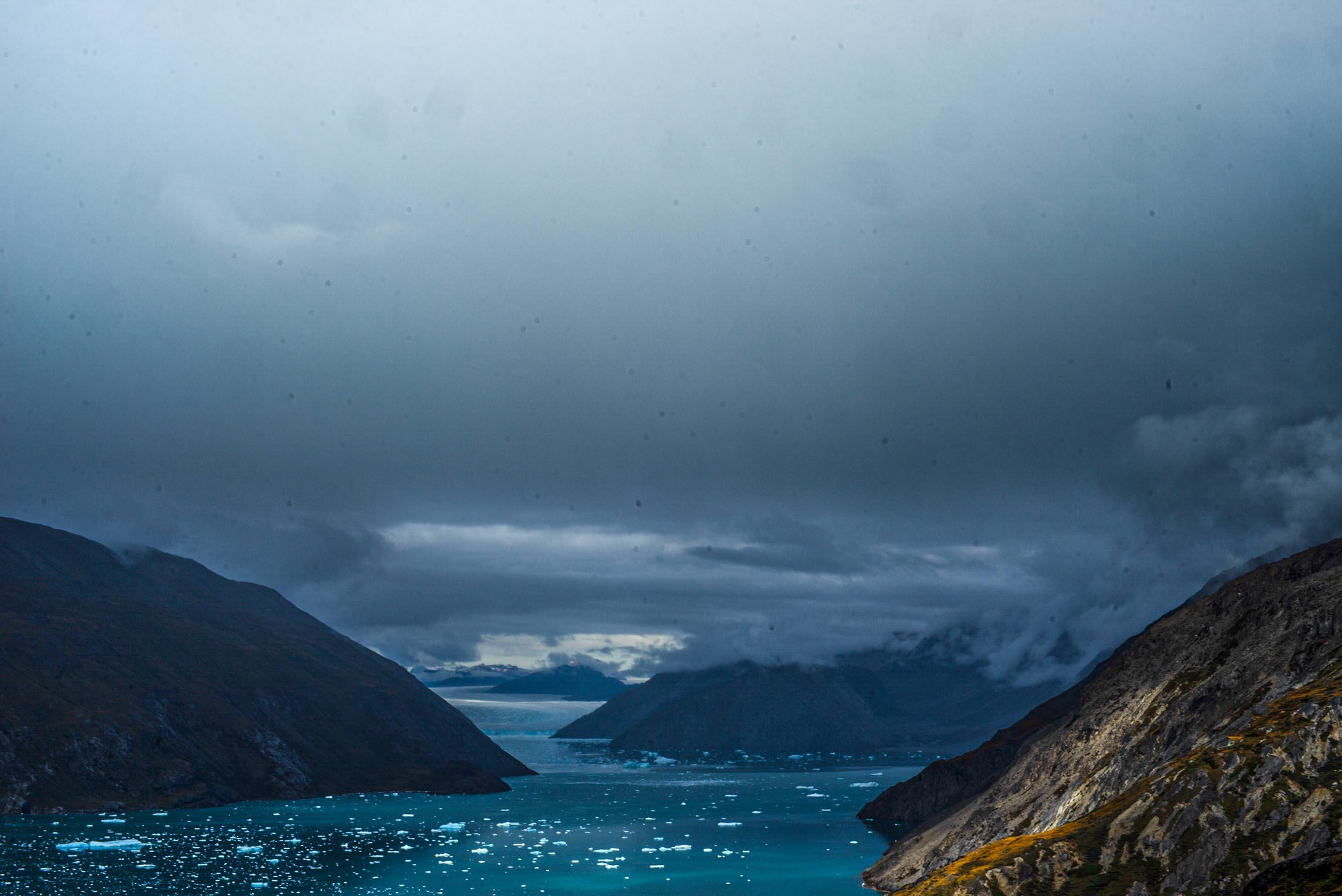 Greenland landscapes with mountains, glaciers, icebergs, a small cabin, and icy waters