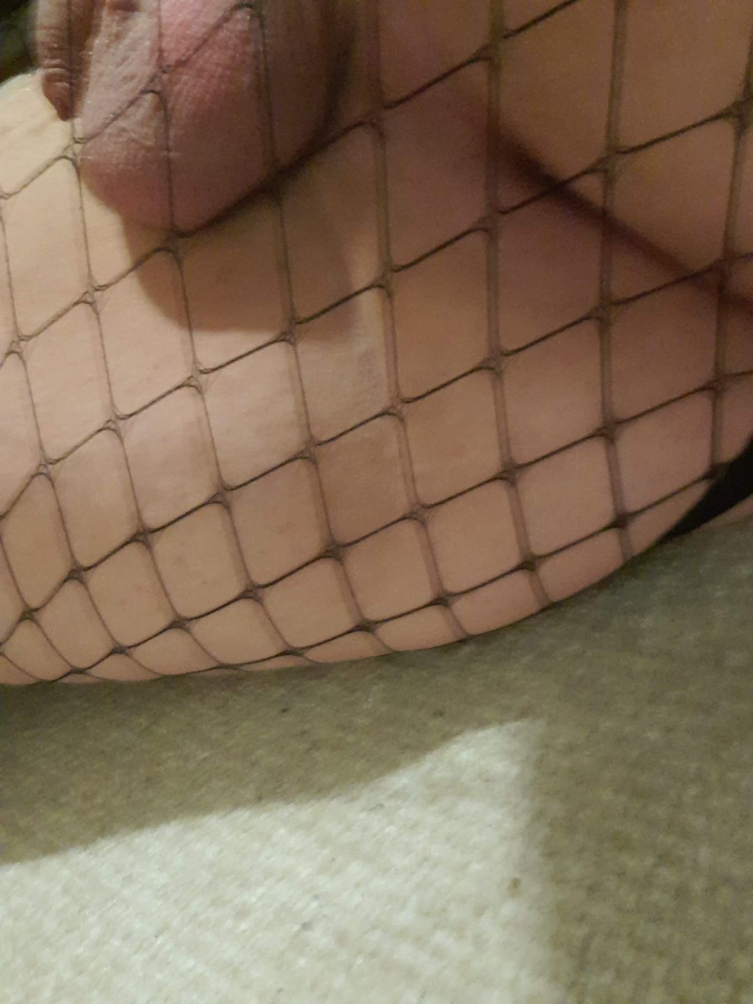 Thick Irish femboy in a black skirt and fishnets posing for a mirror selfie
