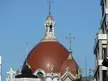 San Juan el Real church dome with ornate white stone carvings and crosses against a blue sky in Mexicana architecture.