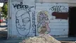 Pop art graffiti of two weird faces on a white wall with a gravel pile, featuring text KEFOR and UGANS
