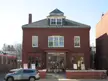 Marblehead, Massachusetts city block featuring the red brick Marblehead Little Theatre and a silver BMW car