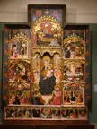 Altar art featuring a multi-paneled religious oil painting with figures in colorful robes and ornate gold frames.