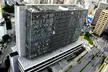 High-angle view of the Municipal Chamber of São Paulo, a modern glass office building in a dense urban city.