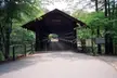 Covered bridge at Stone Mountain surrounded by lush green trees with a weight limit sign.