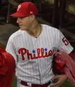 Ríos in a Philadelphia Phillies white pinstripe jersey and red baseball cap with a neck tattoo
