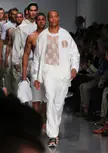 Male models walking a fashion runway in white lace tops, athletic wear, and streetwear