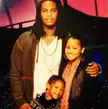 Waka Flocka, Tammy Rivera, and Charlie posing together in a group photo with pink lighting.