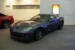Blue and red supercars parked in a showroom next to a Ghostbusters poster