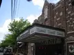 Larchmont movie playhouse brick building with a marquee and a person in a white shirt