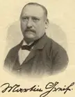 Martin Greif in a black and white gravure portrait wearing a dark suit and bowtie