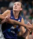 Alanna Smith, a muscular woman and power forward in a blue basketball jersey with a forearm tattoo.