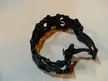 Leatherman Tread industrial metal bracelet with linked segments and screws on a white surface
