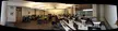 PC gaming desk setups in a wide panoramic view of a computer lab with monitors, desks, and office chairs.