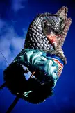 A shimmering blue and silver fish sculpture against a deep blue sky, styled as beast monster concept art.