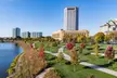 Battelle Riverfront Park with autumn trees, walking paths, a river, and the Columbus city skyline and bridge.