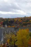 Fall colors at Mt. Tremblant featuring houses and autumn trees under a cloudy sky.