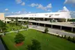 Southwest Florida International Airport terminal with multi-level roadways, cars, and green lawns under a blue sky