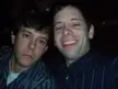 Two men with brown hair and striped shirts smiling in a close-up selfshot
