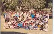 Kasturi Lal Chopra with a group of people in traditional Indian attire and casual wear on a grassy area with trees.
