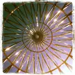 The Rising: a golden circular architectural structure with radiating beams against a blue sky