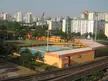 Aerial view of Delta Sports Complex in Singapore featuring swimming pools, a sports field, and surrounding apartment