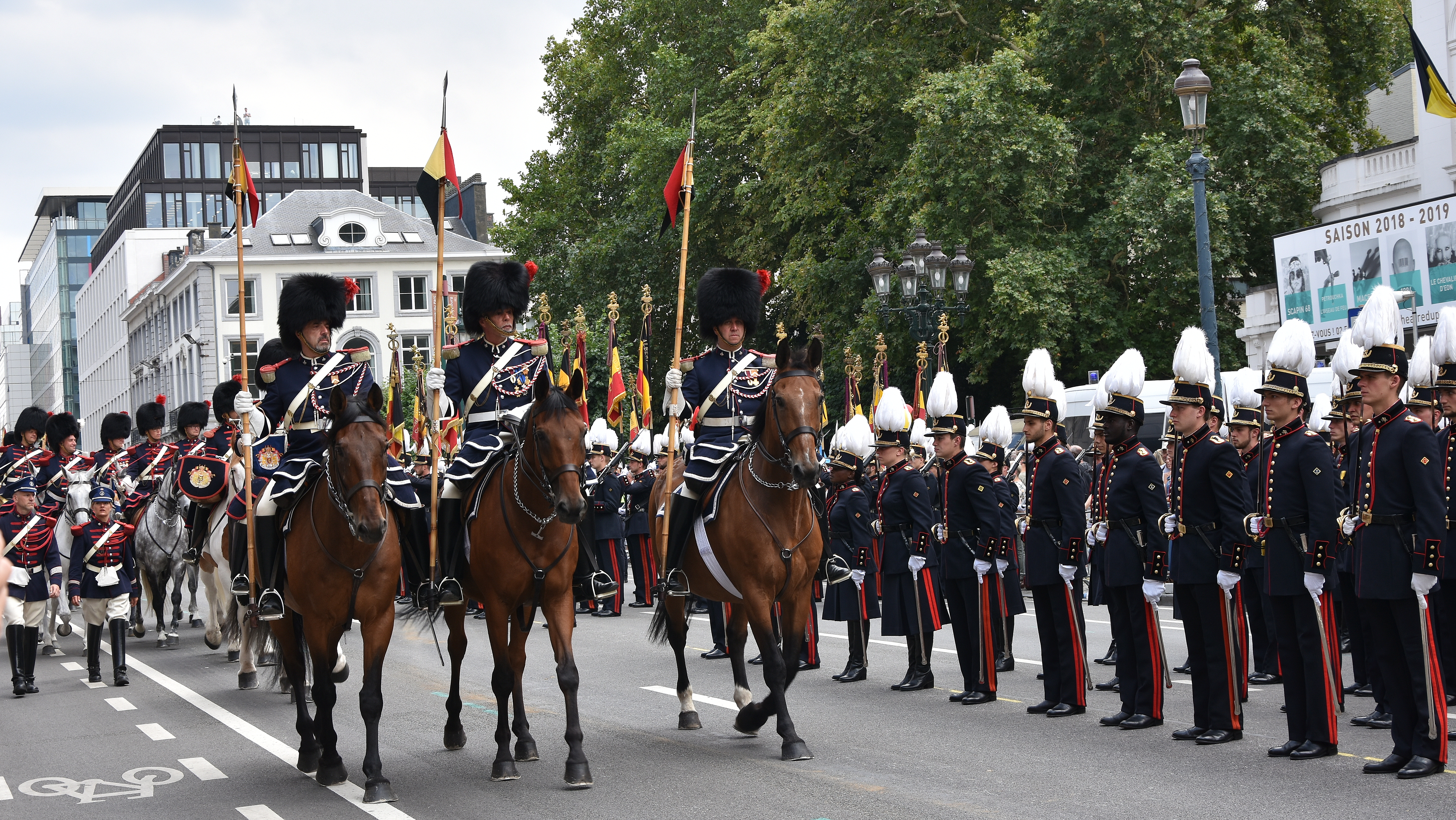 Soldiers in elaborate uniforms on horseback parading